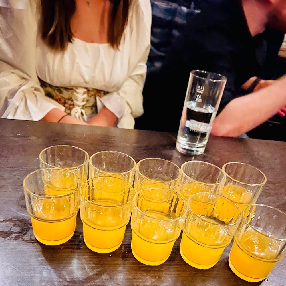 Nine glasses of orange juice on a table.
